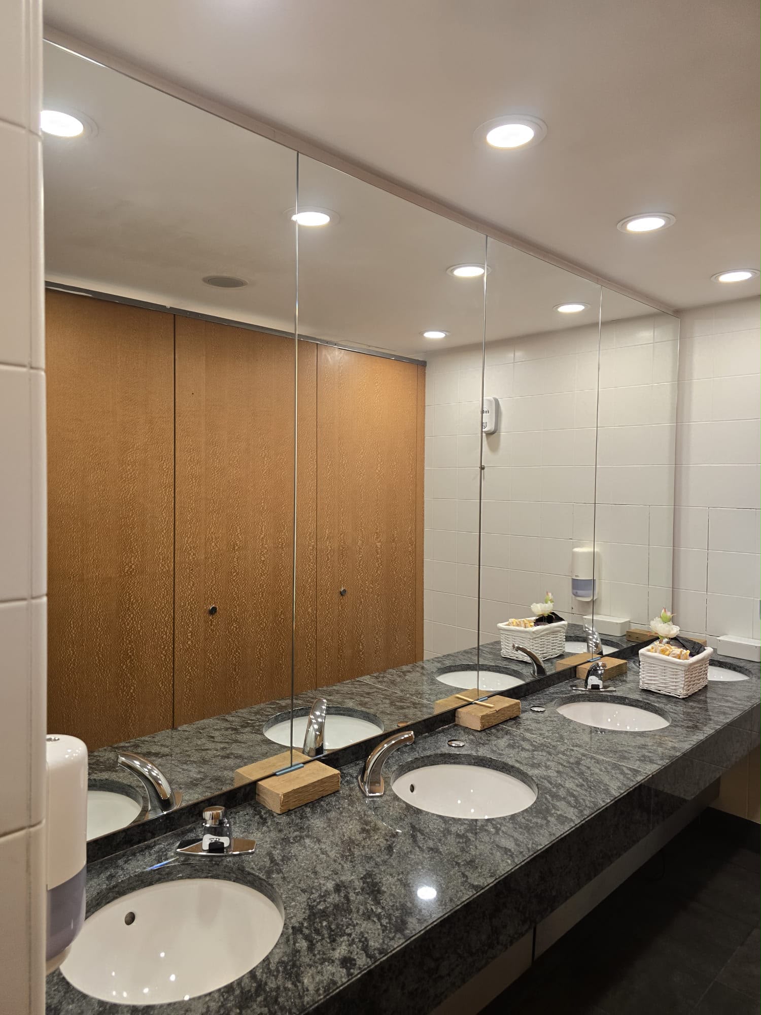 Full-height frameless mirror panels in a commercial washroom