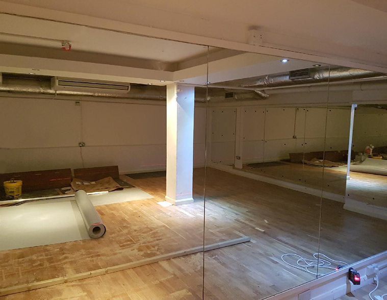 Floor-to-ceiling frameless mirror panels in a dance / fitness studio