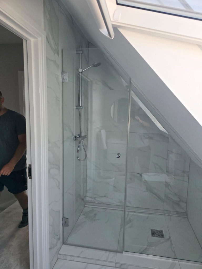 Frameless glass shower enclosure under a sloped loft ceiling