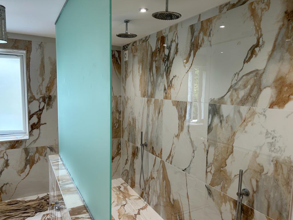 Frosted glass shower screen in a marble-clad bathroom