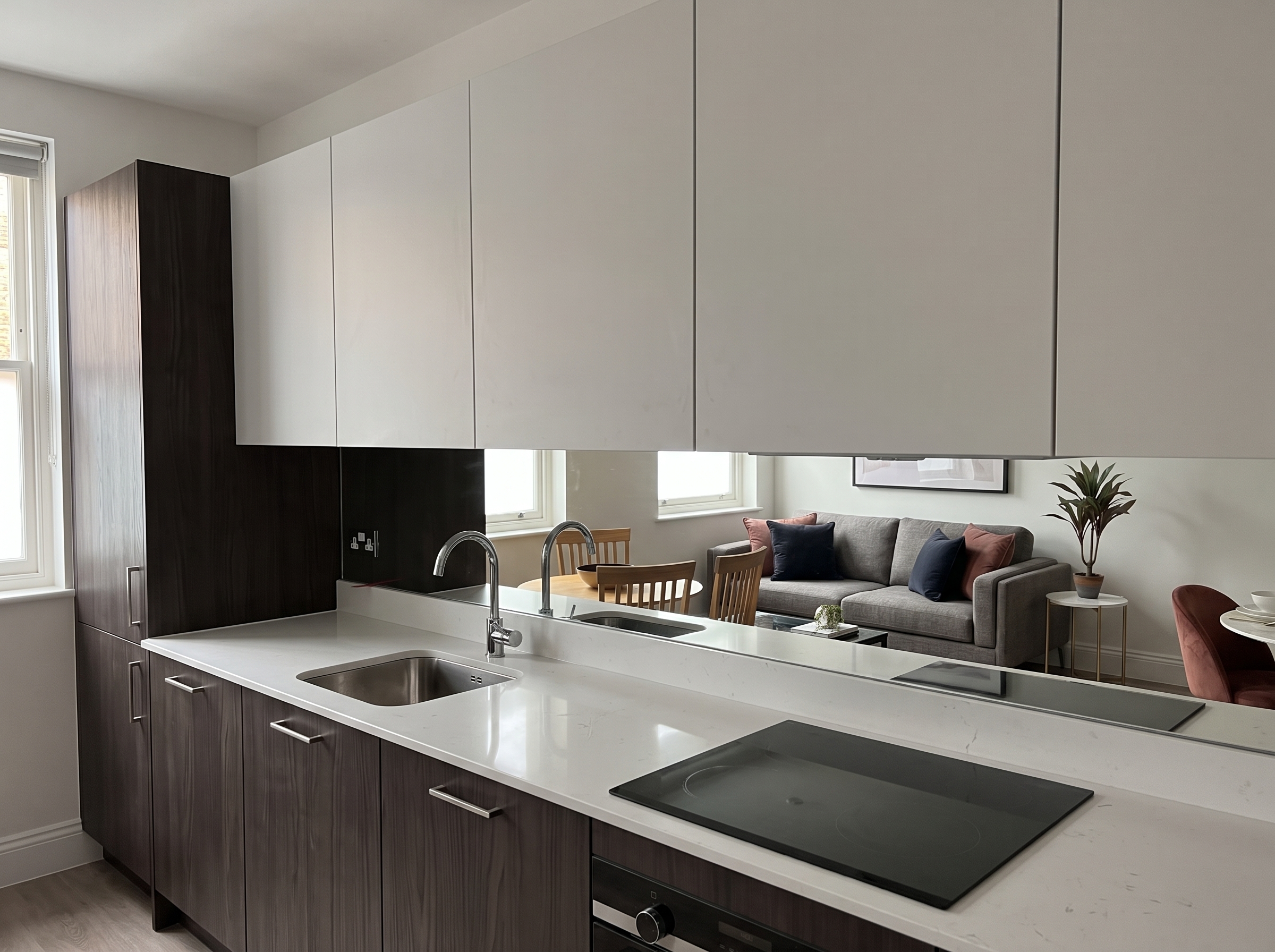 Smoke-tinted mirror splashback over a dark-wood handleless kitchen